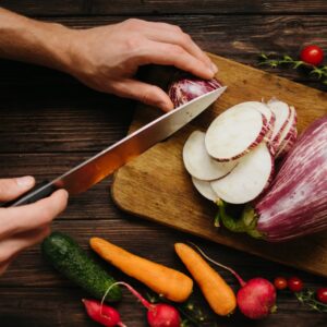 Colorful vegetables being sliced for a fresh, homemade meal.