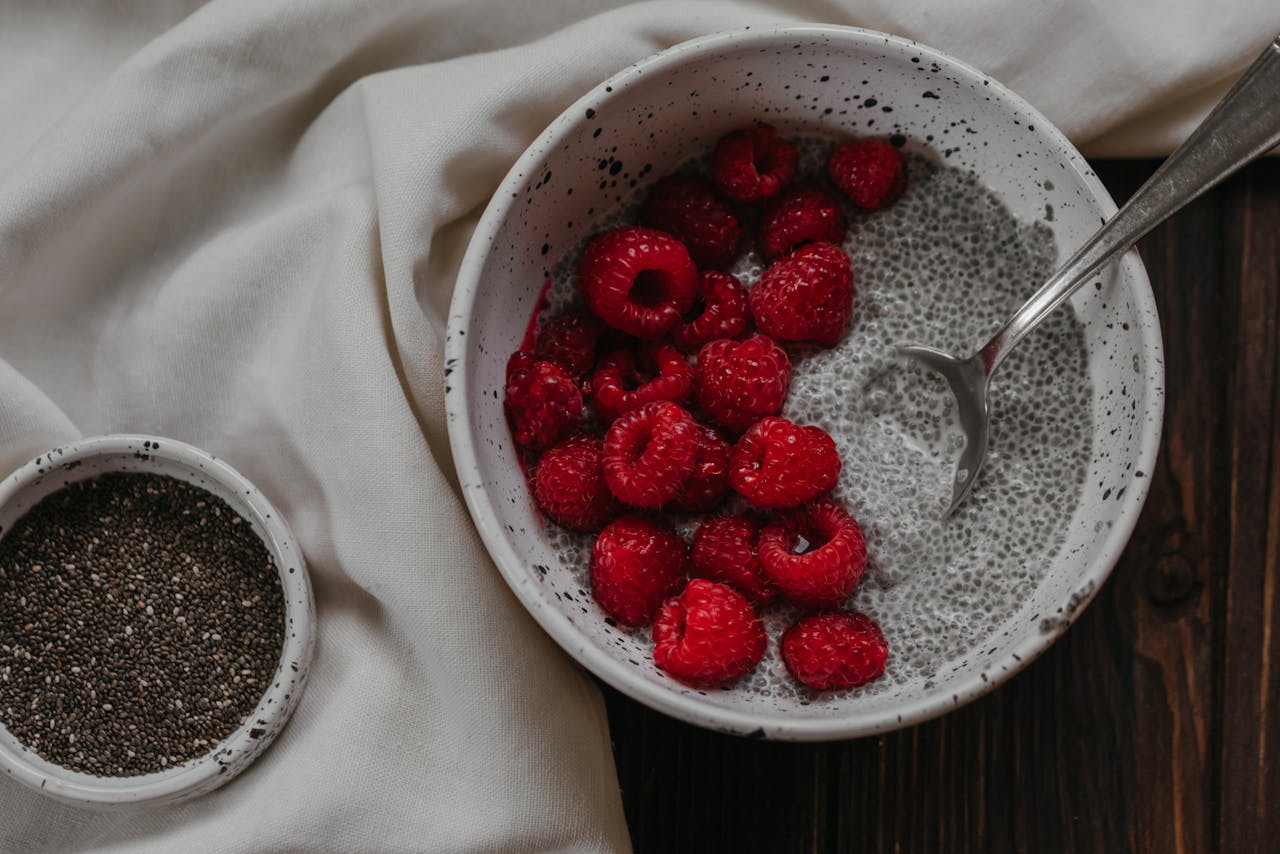 Bowl of chia pudding topped with fresh raspberries, perfect for a healthy breakfast.