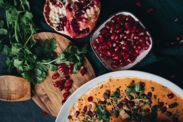 Delicious vegan dish garnished with pomegranate and fresh cilantro, perfect for fall dining.